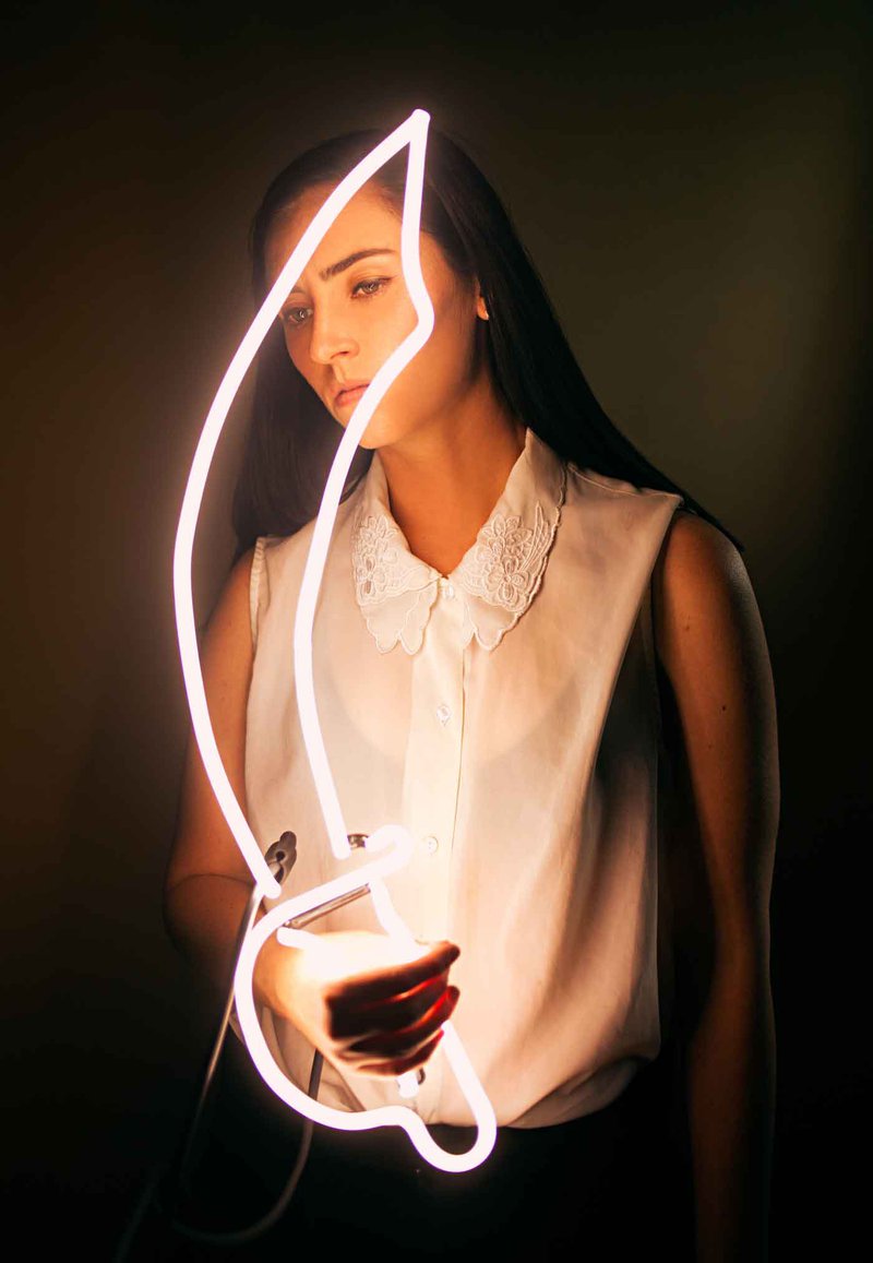 Dani Bonnet, Los Angeles neon artist, holding a lit neon flame tube